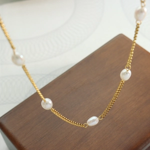 Elegant gold titanium necklace featuring a flat chain with baroque freshwater pearls