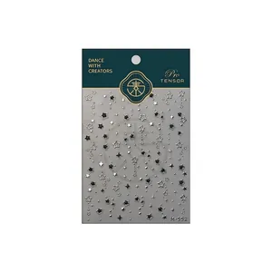 Autocollants nail art étoiles M-552 avec motifs noirs et argentés sur carte bleue