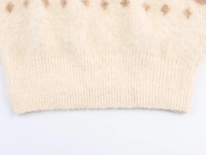 Close-up of cream knit sweater showing fuzzy mohair texture and brown argyle pattern