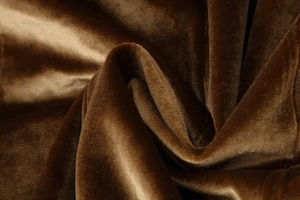 Detailed close-up of dark brown velvet fabric showing soft texture and glossy reflections