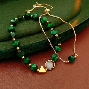 Detail of beaded bracelet with green faceted beads and adjustable gold pull-chain