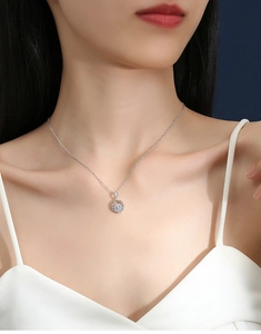 Close-up of a 925 sterling silver geometric circle pendant with 0.5ct moissanite on model