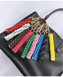 Macro view of colorful handmade braided nylon keychains with gold swivel clasps on a bag