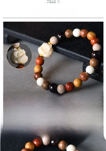 Dettaglio macro del bracciale con perline di legno e ciondolo a testa di leone intagliato