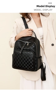 Detail of fashion black leather backpack showing glossy checkerboard pattern and handle
