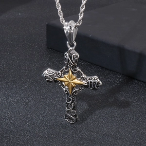 Close-up of gothic cross pendant with golden starburst and silver floral engraving