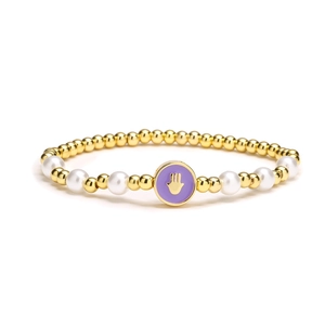 Bracelet perlé Main de Hamsa avec perles dorées et perles blanches sur fond blanc