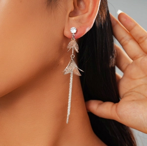 Détail de boucles d'oreilles pendantes fleurs argentées et zircons sur mannequin