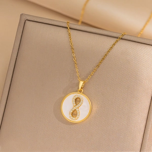 Luxury gold necklace with number 8 zircon pendant on white shell and beige jewelry box