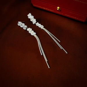 Elegant silver long tassel earrings featuring baguette-cut zircon crystals on velvet background