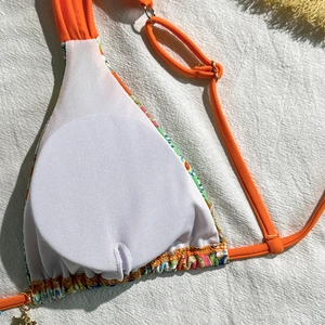 Detail of bikini top showing orange straps and breathable white mesh lining texture