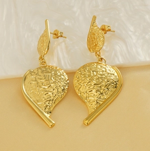 Detailed close-up of golden irregular leaf earrings with textured 3D relief surface