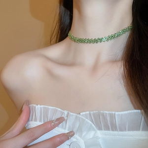 Close-up of a sparkling light green rhinestone choker necklace worn by a model