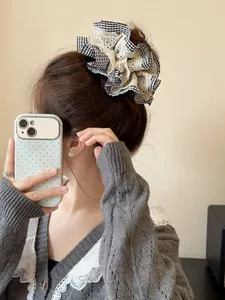 Detailed view of houndstooth and lace scrunchie worn on model for a stylish look