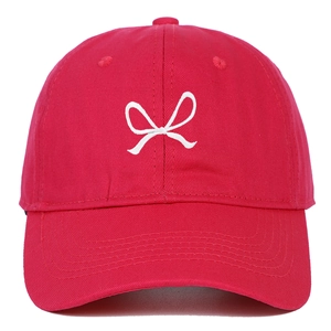 Detailed close-up of a red cotton baseball cap featuring white bow ribbon embroidery