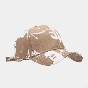 Detail of vintage washed khaki baseball cap with white paint splatter artistic design