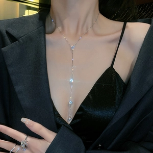 Close-up of sparkling zircon tassel body chain on a black suit jacket for women