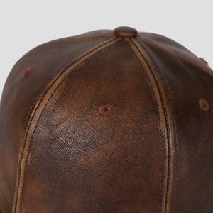 Primo piano del cappello da baseball in pelle PU marrone con cuciture e occhielli
