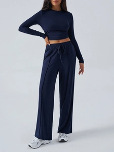 Detailed view of dark blue long-sleeve crop top and drawstring wide-leg yoga trousers set