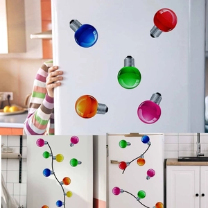 Macro detail of colorful bulb-shaped Christmas magnets arranged on white refrigerator surface