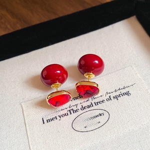 Macro shot of French vintage red resin stud earrings with gold metal detailing