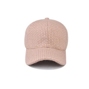 Detailed close-up of light brown knitted baseball cap with thick winter thermal texture
