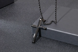 Pendentif croix en acier inoxydable noir poli avec chaîne torsadée sur fond sombre