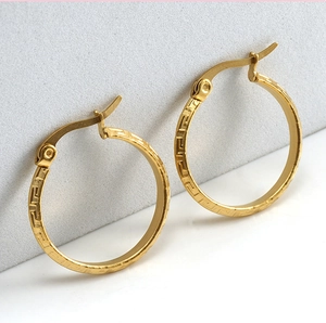 Detailed close-up of gold 18K stainless steel hoop earrings with Greek key pattern