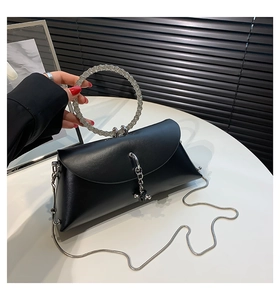 Detail of black jelly bag featuring rhinestone-encrusted round handle and metal chain