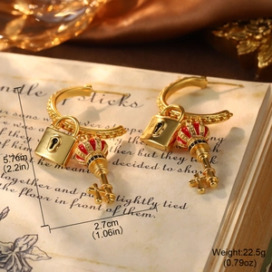 Detail of vintage gold hoop earrings with crown key and lock charms with enamel work