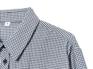 Close-up of the black and white gingham shirt fabric texture and neckline stitching