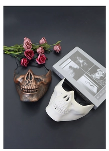Detailed relief of bronze skull mask with vintage roses and old books for Halloween