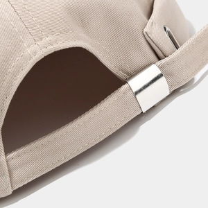 Detailed macro view of the beige cotton cap showing metal buckle and adjustable strap