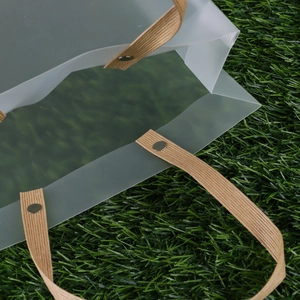 Frosted semi-transparent PP gift bag with brown reinforced handles and metal rivets