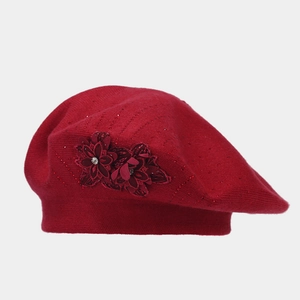 Detail of red knitted beret showing 3D fabric flower with delicate beads embellishment