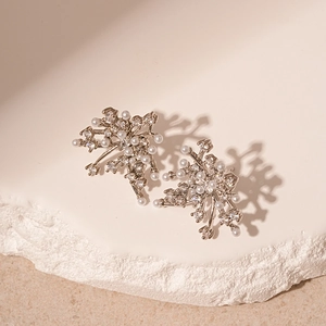 Elegant silver flower earrings with pearls and zircon crystals on stone display