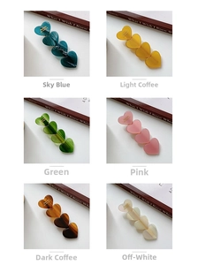 Macro detail of heart-shaped acetate hair clips in multiple marble texture colors