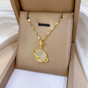 Detail of gold planet necklace with white cat eye stone and cubic zirconia star pendant