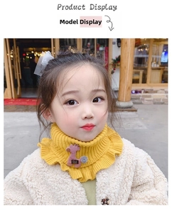 Detail of yellow knitted kids neck warmer with ruffle edge and cute giraffe patch