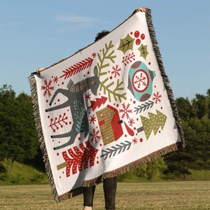 Close-up of woven Christmas throw blanket with reindeer and fringe edge detail