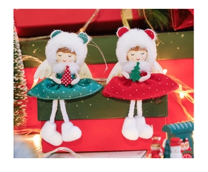 Detail of red and green plush Christmas angel dolls sitting on festive gift boxes