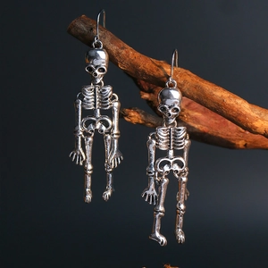 Macro shot of silver skeleton earrings hanging on a branch with dark moody lighting