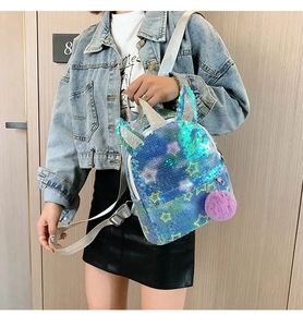 Close-up of blue sequin unicorn backpack with silver ears and purple pom-pom detail