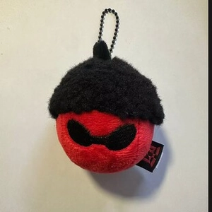 Detail of red plush ball ornament with black sunglasses, hat and bead chain