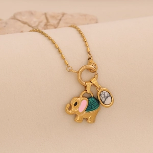 Detailed close-up of a gold elephant pendant necklace with enamel and white oval stone