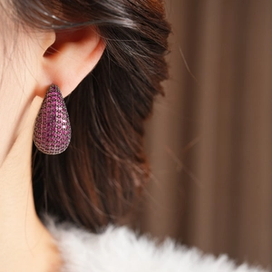 Macro shot of vintage teardrop earrings with pink pavé stones on dark metal base