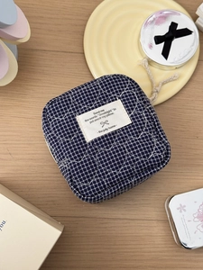 Detail of navy blue quilted heart pattern and woven label on a fabric pouch