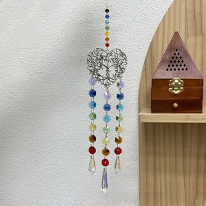 Detail of colorful faceted crystal beads and silver hollow tree of life heart pendant