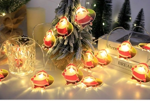 Close-up of Santa Claus LED string lights with warm glow on a small Christmas tree