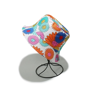 Close-up of vibrant daisy floral prints on a white bucket hat for summer sun protection